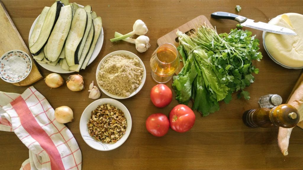 Top view of fresh vegetables and ingredients on a wooden table, ideal for healthy recipes.