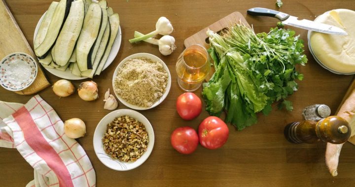 Top view of fresh vegetables and ingredients on a wooden table, ideal for healthy recipes.